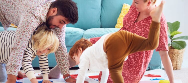 A family with young children playing Twister.