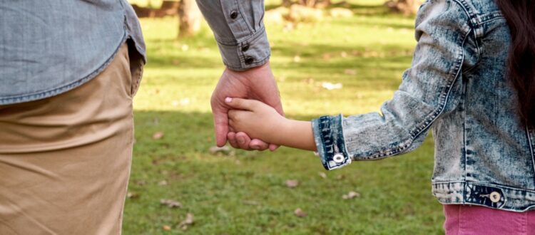 Parent and child holding hands.