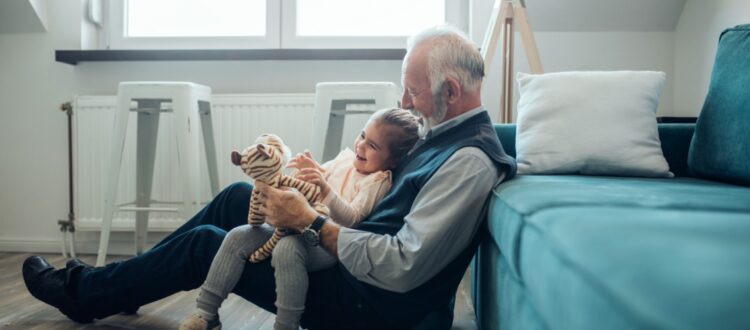 A grandfather playing with his granddaughter.