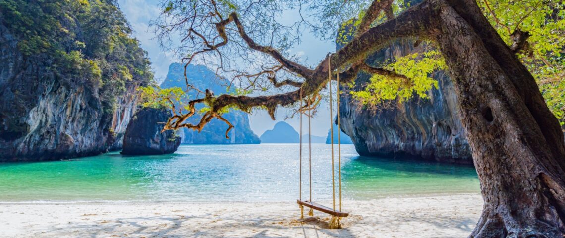 A beach with a swing hanging from a tree in Laos.