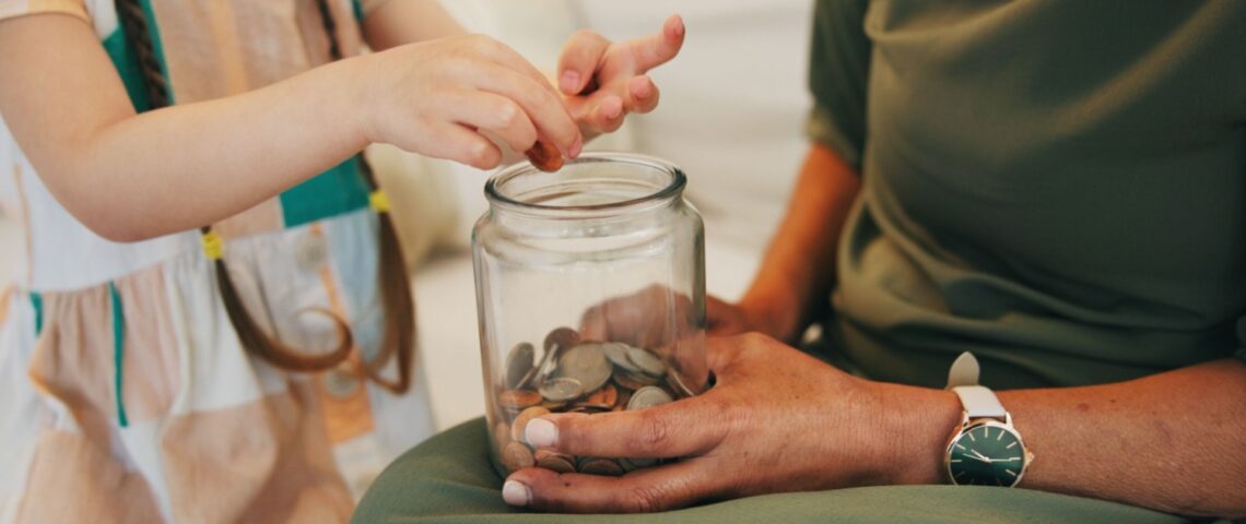 A child counting money in a jar.