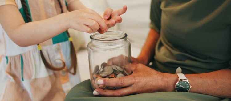 A child counting money in a jar.