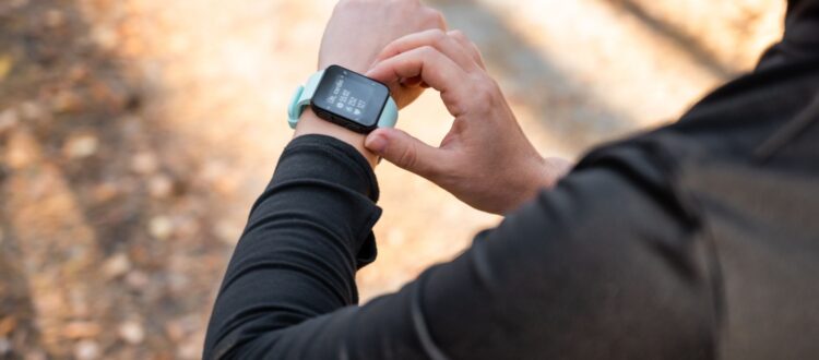 A runner looking at the time on their watch.