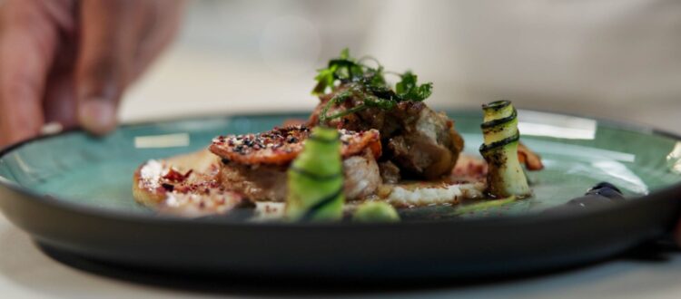 A chef prepares a dish in a fine dining restaurant.