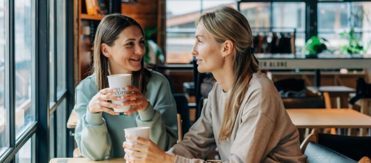 Two women talking in a coffee shop.