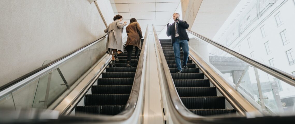 People using escalators in an office building.