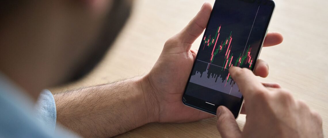 A man looking at investment performance on his phone.