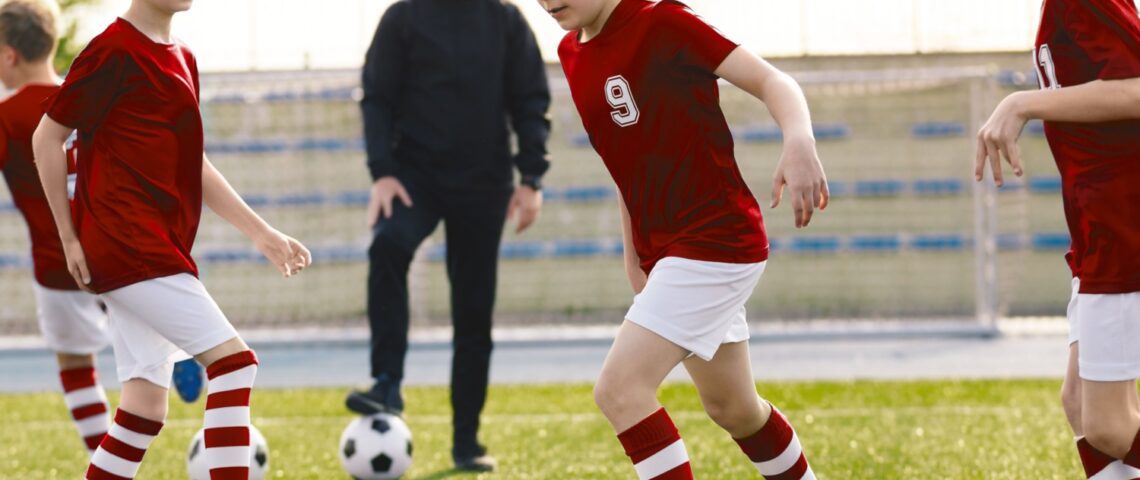 A children’s football coach watching a training session.