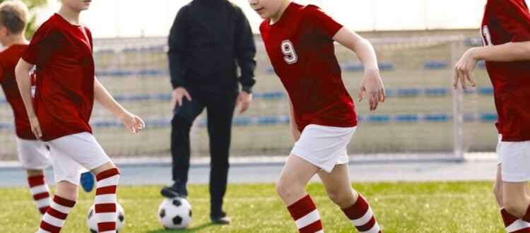 A children’s football coach watching a training session.
