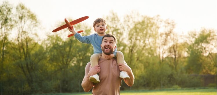 A father with a child sitting on his shoulders.