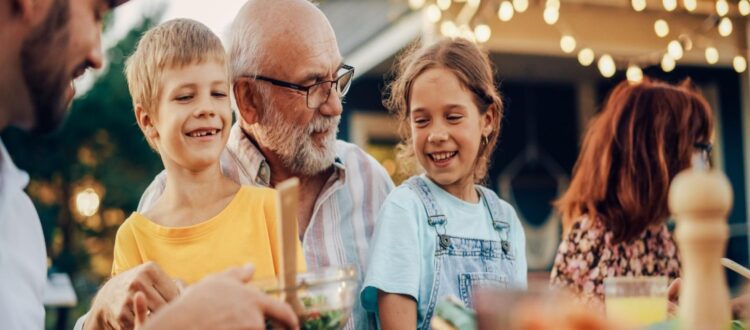 A grandfather laughing with his grandchildren.