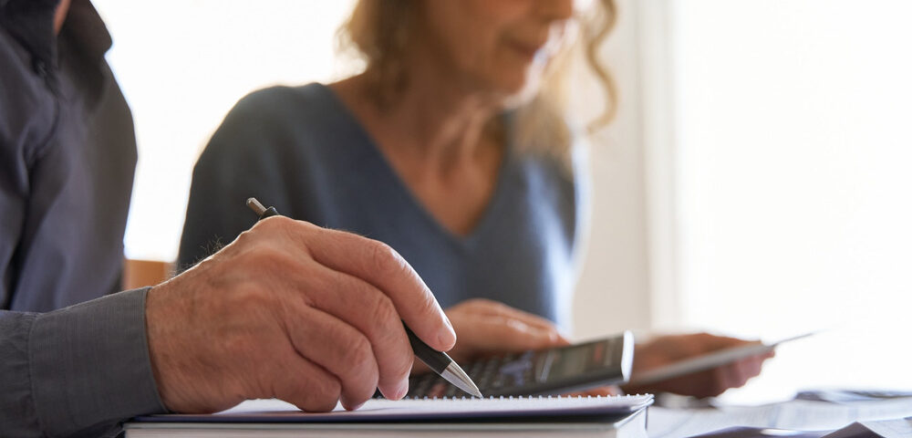 Couple looking at paperwork and using a calculator