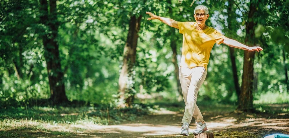 A woman doing balancing exercises outdoors.