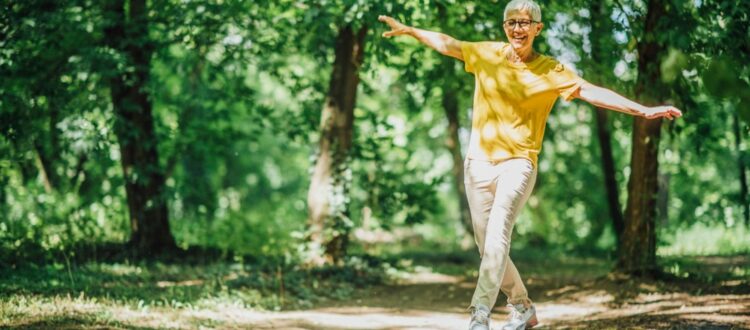A woman doing balancing exercises outdoors.