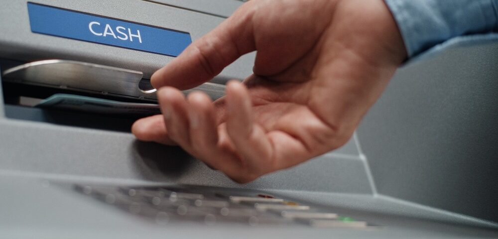 A person using an ATM to withdraw cash.