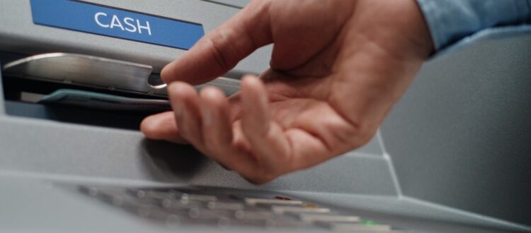 A person using an ATM to withdraw cash.