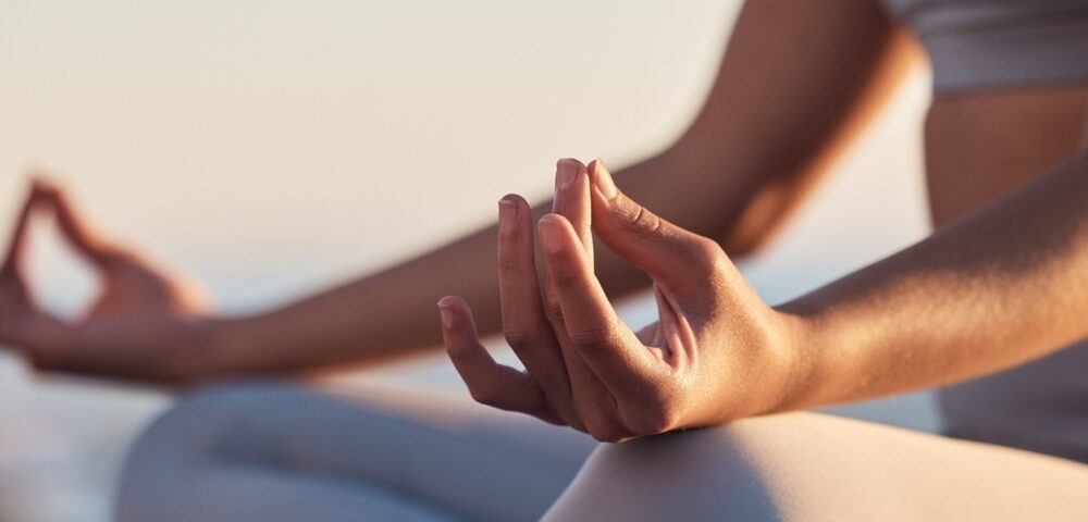 A woman sitting in the lotus position mediating.