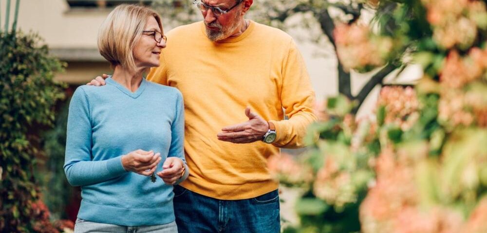 Mature couple walking outside a house
