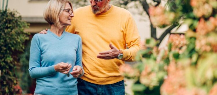 Mature couple walking outside a house