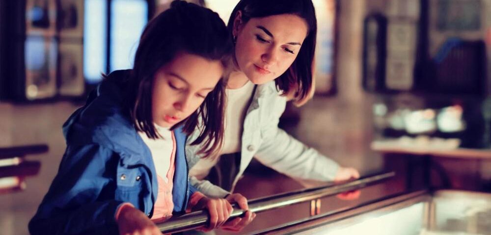 A mother and daughter viewing a museum exhibit.