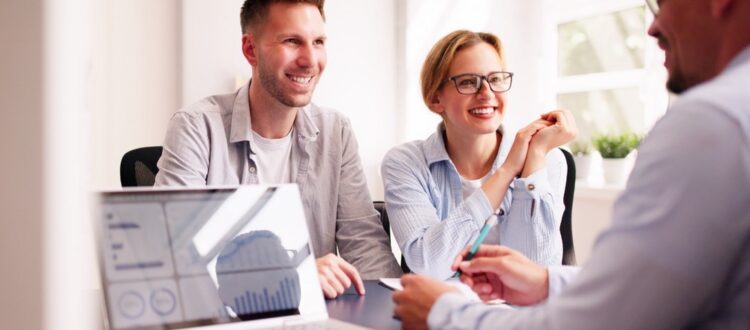 A couple happily talking with their financial planner.